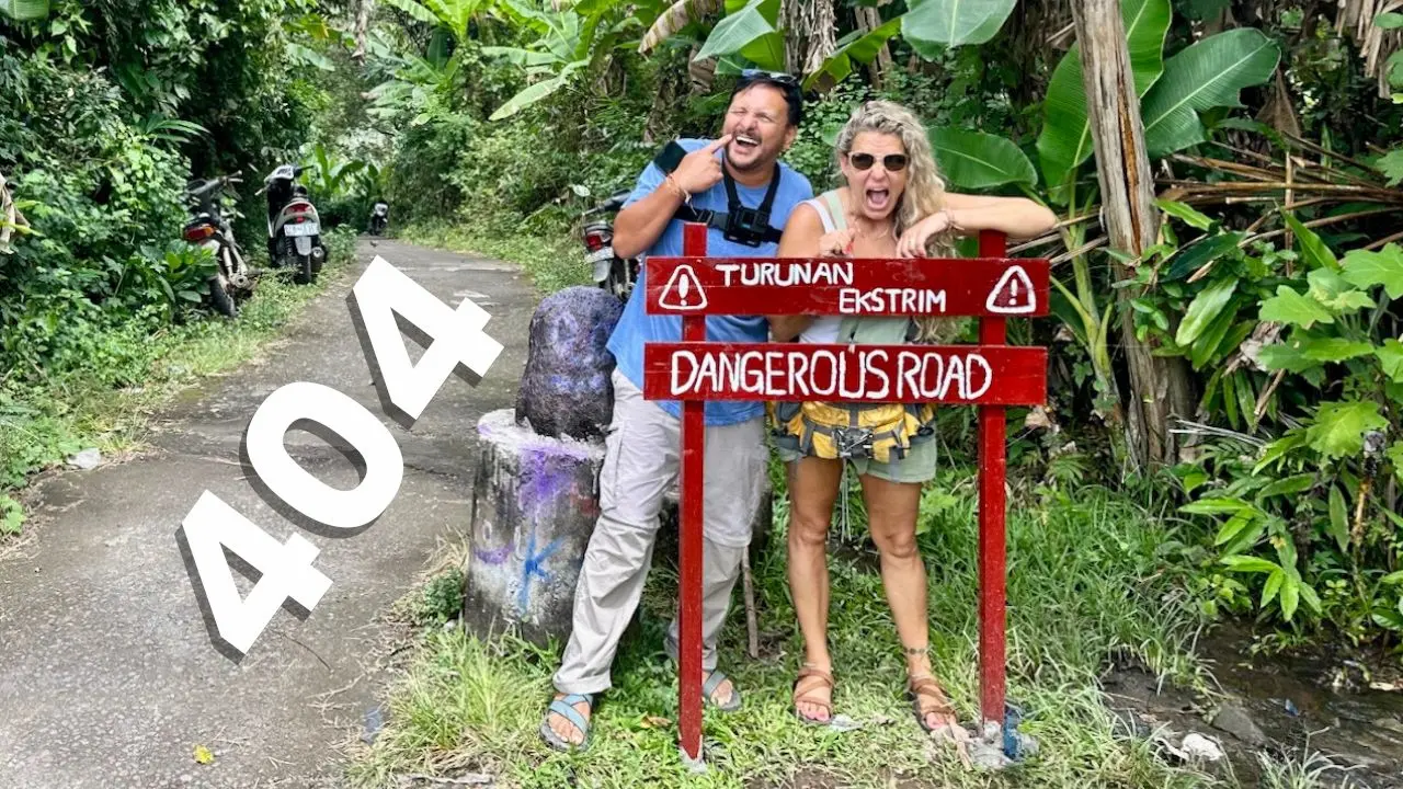 A picture of a man and a woman standing in front of a funny misspelled sign that says turn around extreme danger